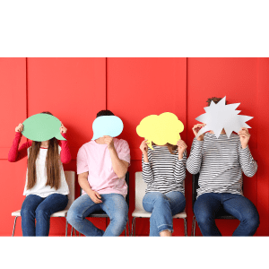 People sitting on a bench with paper speech bubbles over their faces.