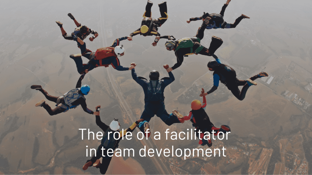 A number of people sky diving and holding hands in formation to show team development