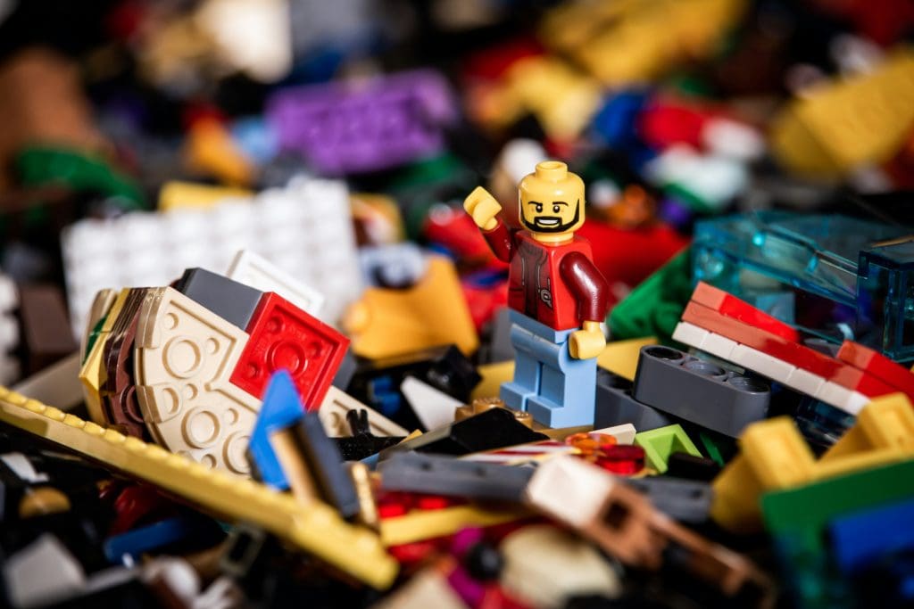 A photo of a lego man on a pile of lego to show that a culture of play is important