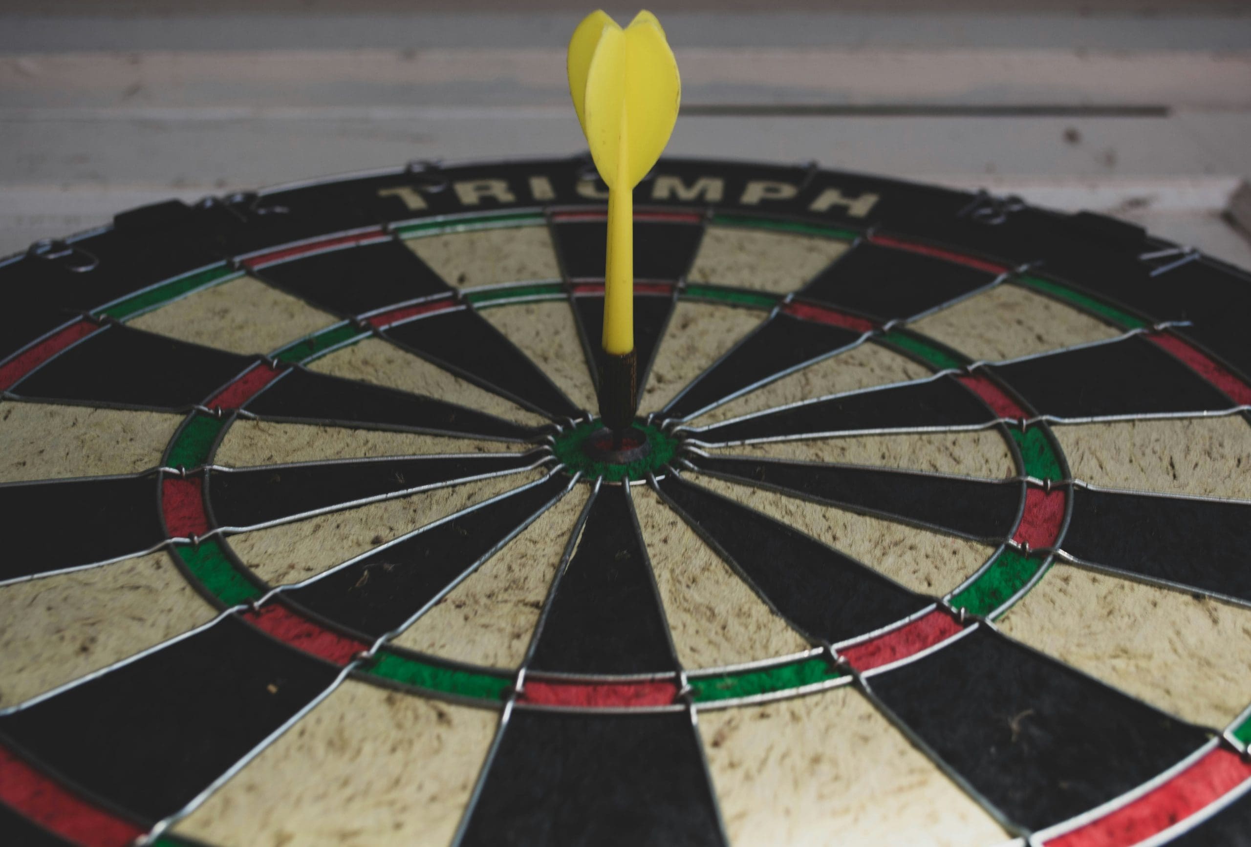 A dartsboard with a yellow dart in the centre to demonstrate the objectives needed for a team away day
